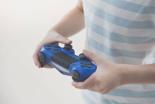 Азіатський дитина тримає ігрової консолі контролера, грати у відеоігри. - Фото, зображення
