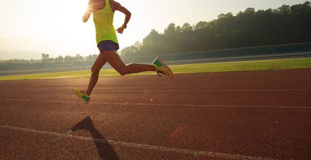 Fitness sportswoman running on sunrise track - Фото, зображення