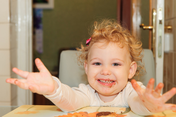 Little girl with dirty facel eating cookie - Photo, Image