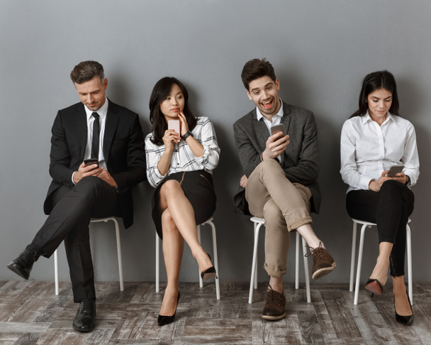 interrazziale uomini d'affari in abito formale con smartphone in attesa di colloquio di lavoro
 - Foto, immagini