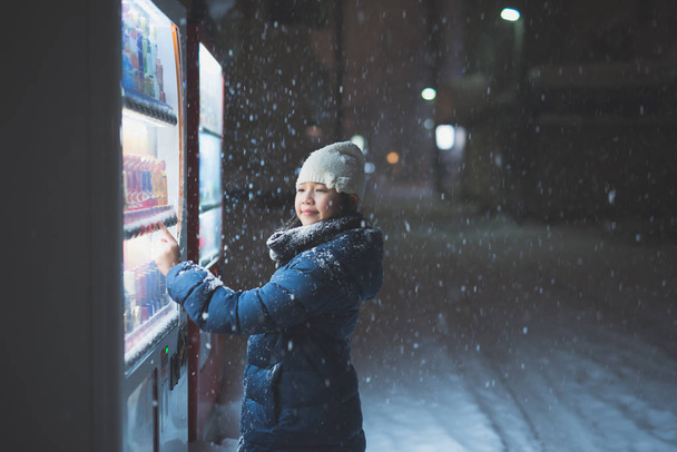 schöne asiatische Mädchen Wahl eines Getränks am Automaten in der Nacht in aomori japan - Foto, Bild