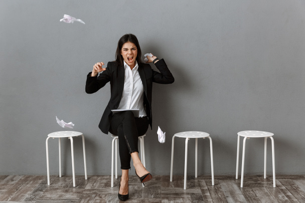 donna d'affari arrabbiata e stressata in giacca e cravatta con documenti avvolti in attesa di colloquio di lavoro
 - Foto, immagini