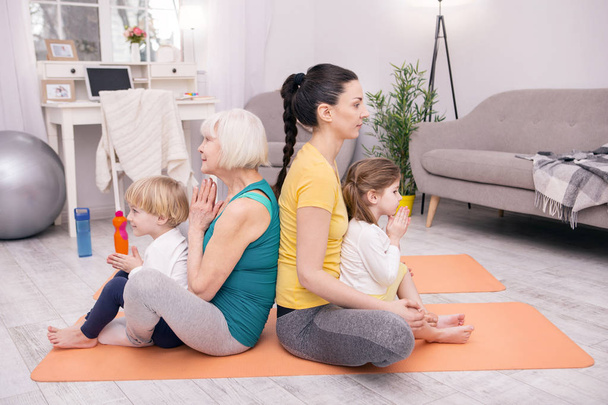 Content women and kids doing yoga - 写真・画像