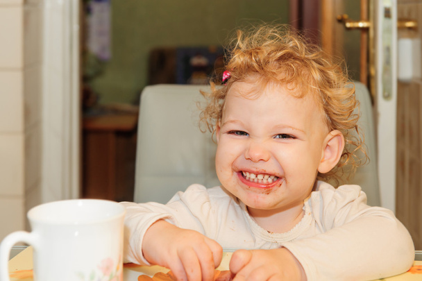 Little girl with dirty facel eating cookie - Φωτογραφία, εικόνα