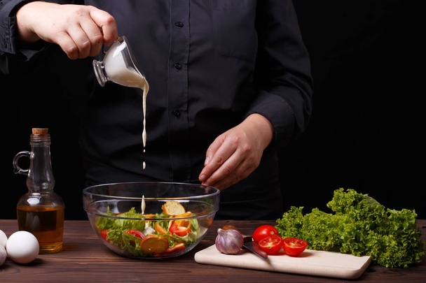 Chef pouring sauce on caesar salad, cooking process, restaurant  - Foto, Imagem
