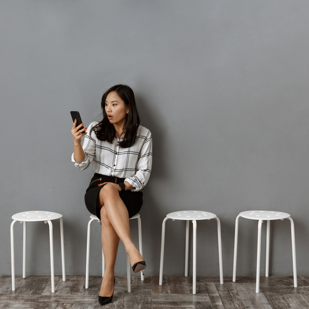 emocional asiático mujer de negocios con smartphone a la espera de trabajo entrevista
 - Foto, imagen