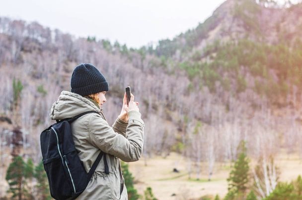 Girl taking photo with phone camera in the mountains - Fotoğraf, Görsel