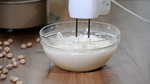 Chef whips cream in a bowl with mixer - Πλάνα, βίντεο