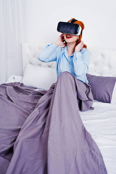 Red haired girl in bed with vr glasses at studio room. - Fotoğraf, Görsel