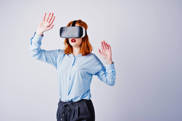 Red haired girl in blue blouse with vr glasses at studio isolate - Photo, image