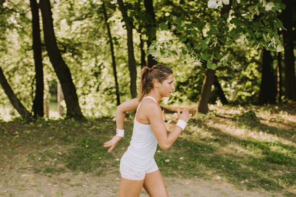Ver a la joven corriendo en el parque en el hermoso día de verano
 - Foto, imagen