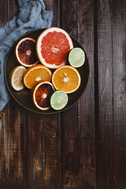 a fából készült asztal halfs, narancs, grapefruit, lime, vérnarancs és citrom-lemez és a konyhai törölköző-felülnézet - Fotó, kép
