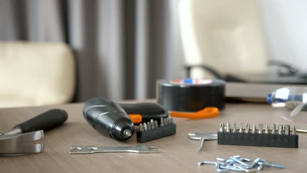 Electric screwdriver lying on a table next to other furniture assemble equipment - Footage, Video