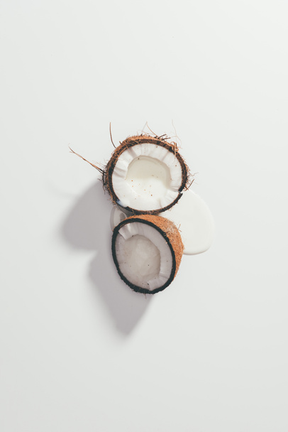 top view of halved organic tasty coconut on white - Foto, Imagem