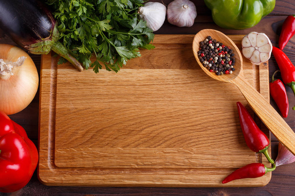 Chopping board, vegetables, herbs and spices in wooden spoon, in - Foto, afbeelding