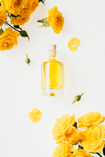 top view of glass bottle of perfume and yellow roses isolated on white - Фото, зображення
