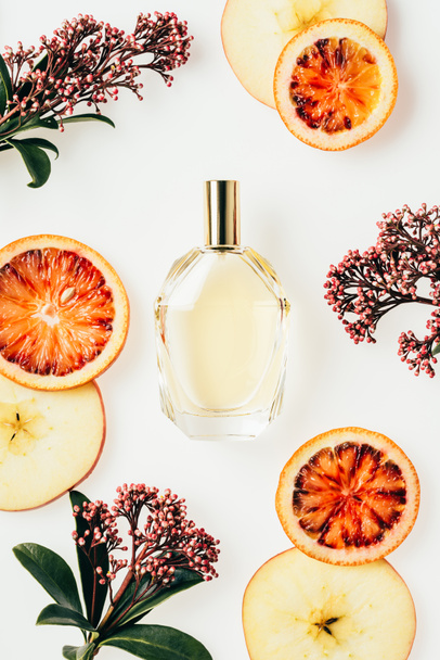 vista superior de frasco de vidrio de perfume rodeado de frutas y flores aisladas en blanco
 - Foto, Imagen