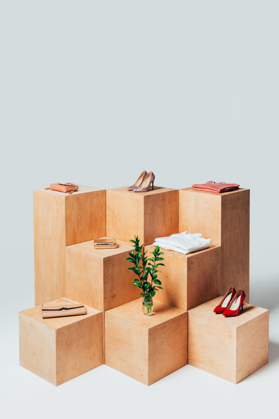 high angle view of high heels and twigs in vase on wooden stands, summer sale concept - Foto, Imagen