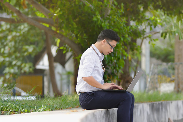 Портрет впевнено молоді азіатські бізнесменом роботи з ноутбука на громадський парк. - Фото, зображення