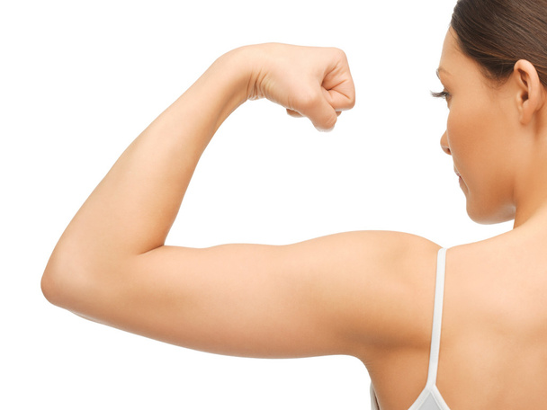 Sporty woman flexing her biceps - Foto, imagen