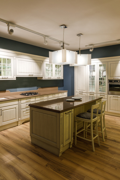 Stylish kitchen with elegant shiny table and chandelier - Фото, зображення