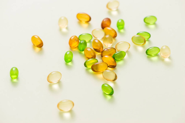 Nutrición y relleno de vitaminas en colorida cápsula de gelatina suave
 - Foto, Imagen