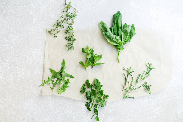 Fresh culinary herbs on white background: rosemary, thyme, mint, arugula, basil and parsley in small bunches - Foto, imagen