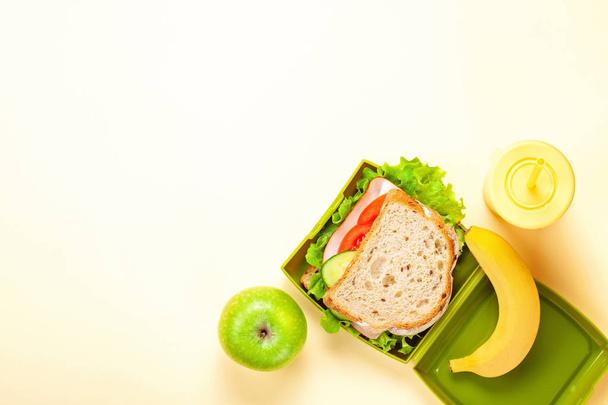 Свіжий бутерброд і яблуко для здорового обіду в пластиковій обідній коробці
 - Фото, зображення
