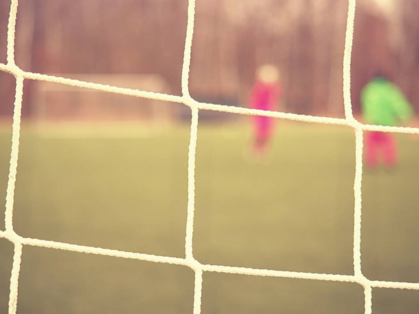 Soccer football net background over green grass and blurry stadium. Close up detail - Foto, imagen