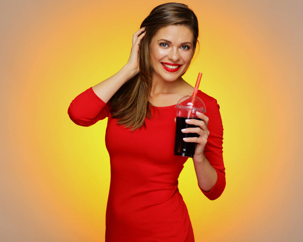 Smiling woman wearing red dress holding cola drink. - Foto, Imagen