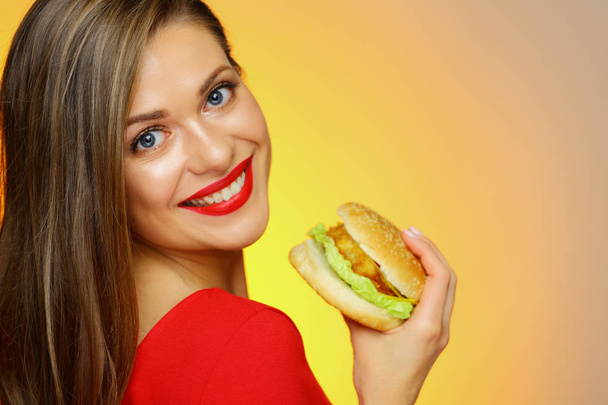 Close up face portrait of woman eating burger.  - Фото, зображення