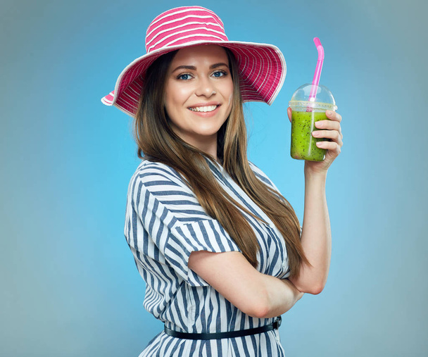 smiling woman wearing striped dress and big summer hat holding detox drink  - Zdjęcie, obraz