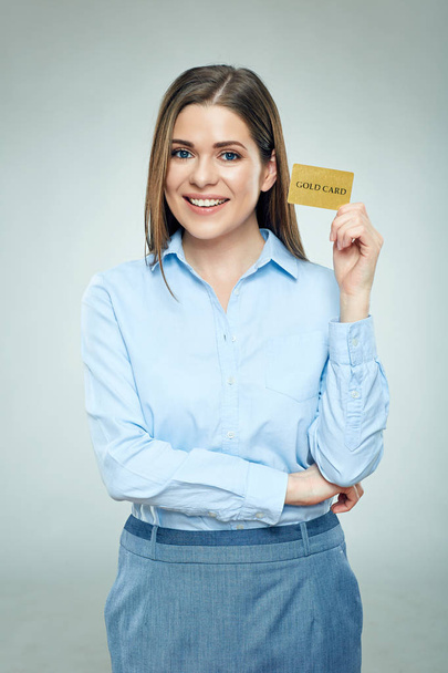 smiling businesswoman in blue shirt holding golden credit card - Фото, изображение