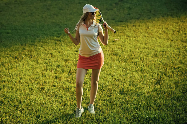 Girl athlete in sexy uniform, cap on green grass - Foto, Imagem