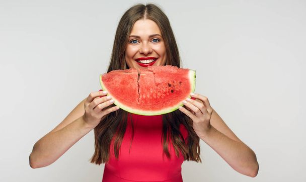 Close up portrait of young woman wearing red dress eating watermelon - Foto, Imagem