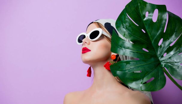 woman in sunglasses with palm leaf - Foto, afbeelding