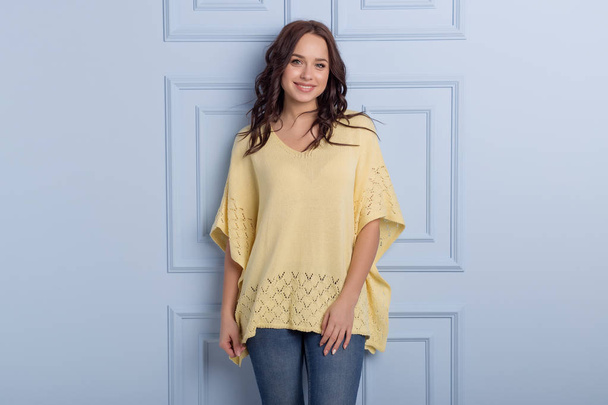 beautiful cute girl with a smile demonstrates knitted clothes - Fotografie, Obrázek