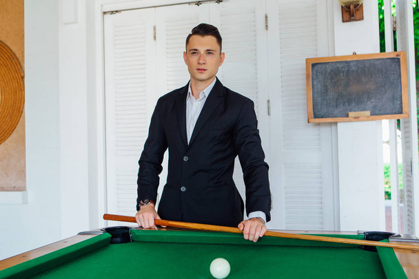 Young handsome man playing billiard game alone - Foto, Imagen