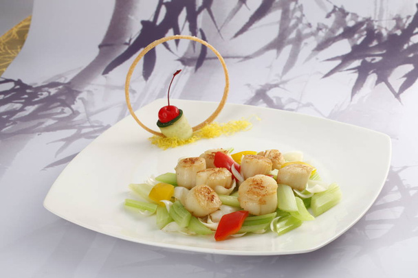 White plate with scallop and celery on table - Photo, image