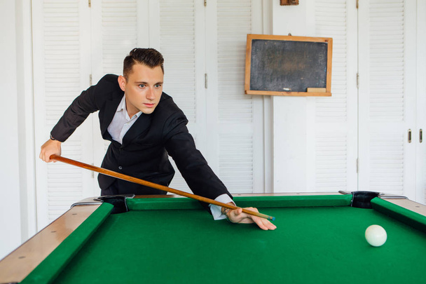 Young handsome man playing billiard game alone - Foto, Imagen