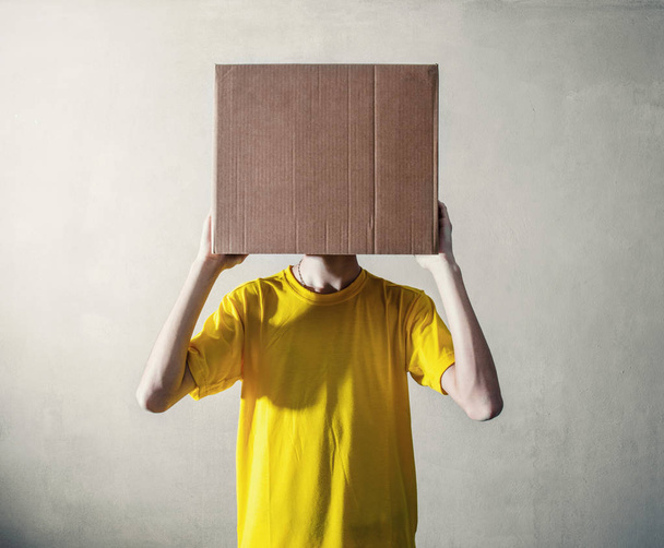 Person with overhead a cardboard box - Foto, Imagen
