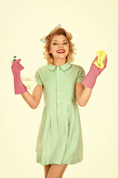 Smiling woman holding bottle of soap for cleaning house. - Valokuva, kuva