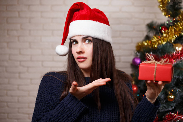 Young cute displeased woman in Santa cap is disappointed with he - Foto, Imagem