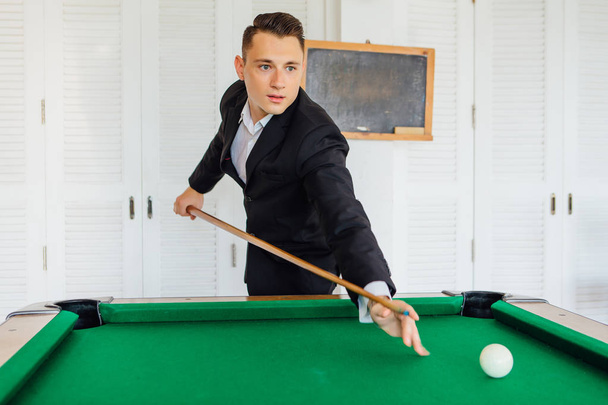 Young handsome man playing billiard game alone - Foto, Bild