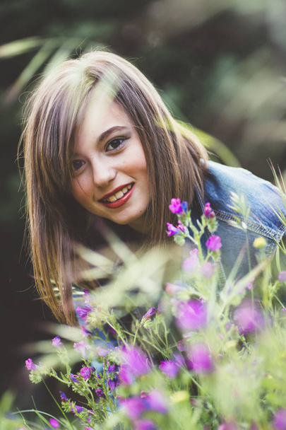Menina adolescente feliz na floresta com flores
 - Foto, Imagem