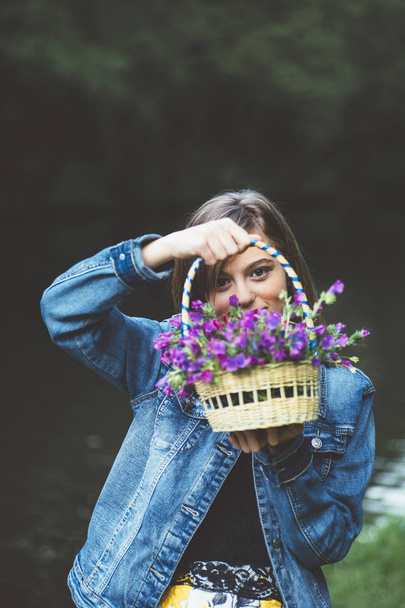 Gelukkig tiener meisje in het bos met bloemen - Foto, afbeelding