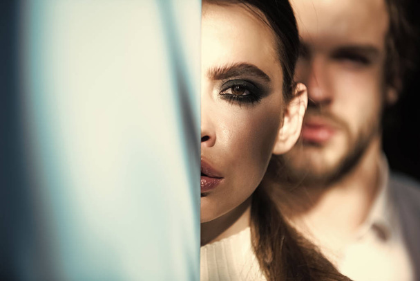 Woman hide half face and blurred man on background - Valokuva, kuva