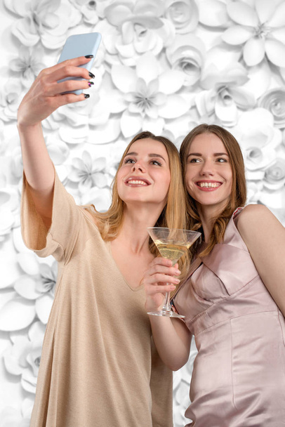 Duas mulheres atraentes jovens em uma fotografia de vestido da tarde eles
 - Foto, Imagem