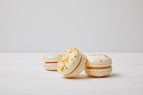 closeup shot of three macarons on white wooden table - Fotografie, Obrázek