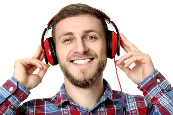 Portrait of young man with headphones on white background - Fotó, kép